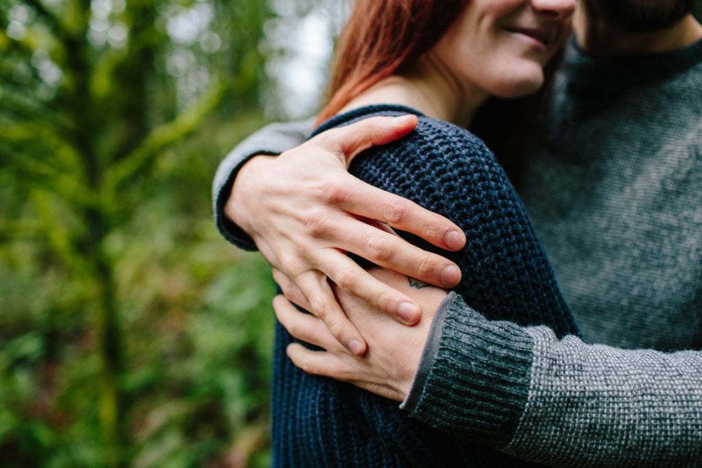 Shaun Hutto, Counseling Evergreen & Westminster: A man in a gray sweater si hugging a redheaded woman in a blue sweater.